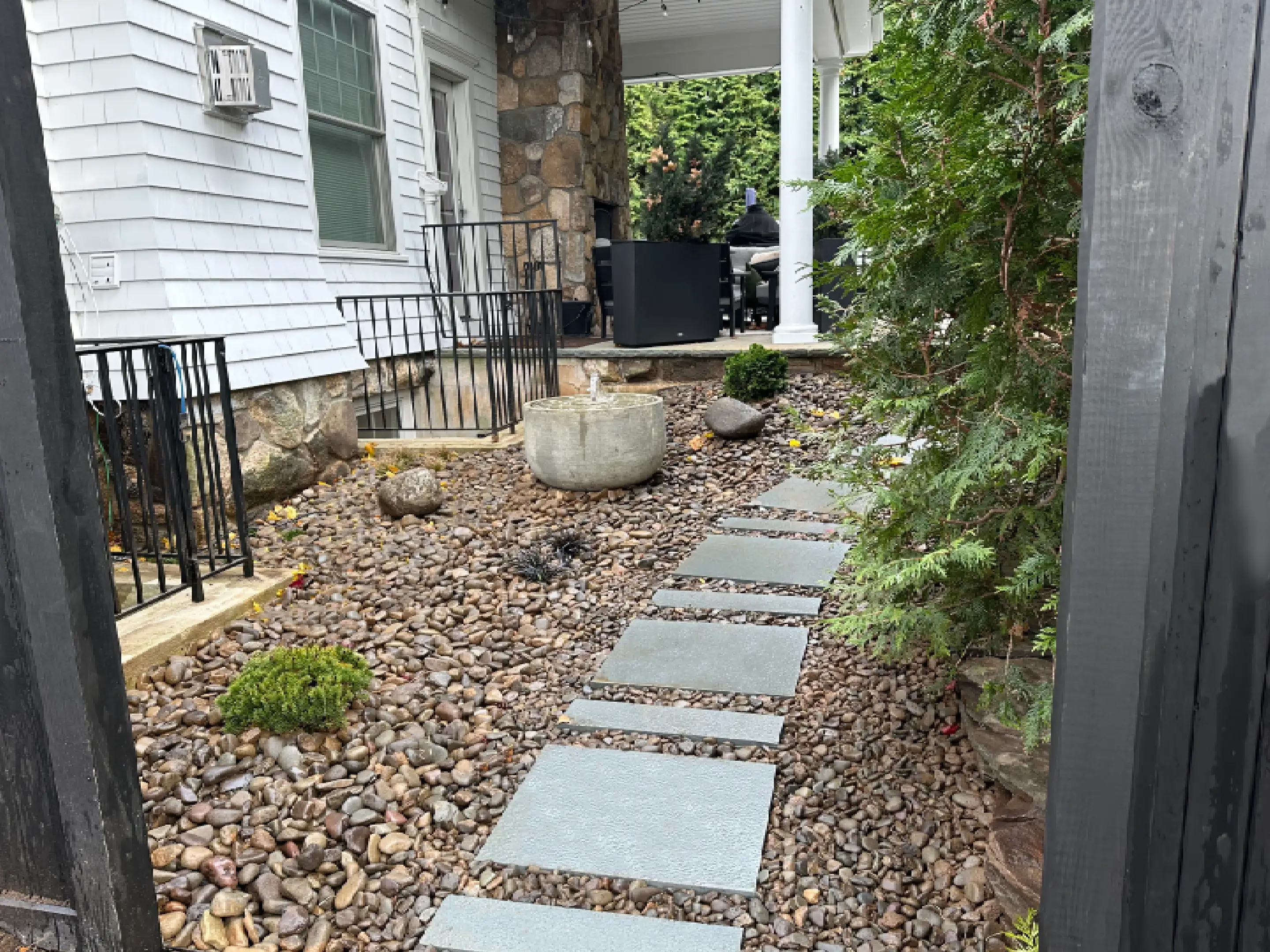 Stone pathway with pebble landscaping beside a house entrance.